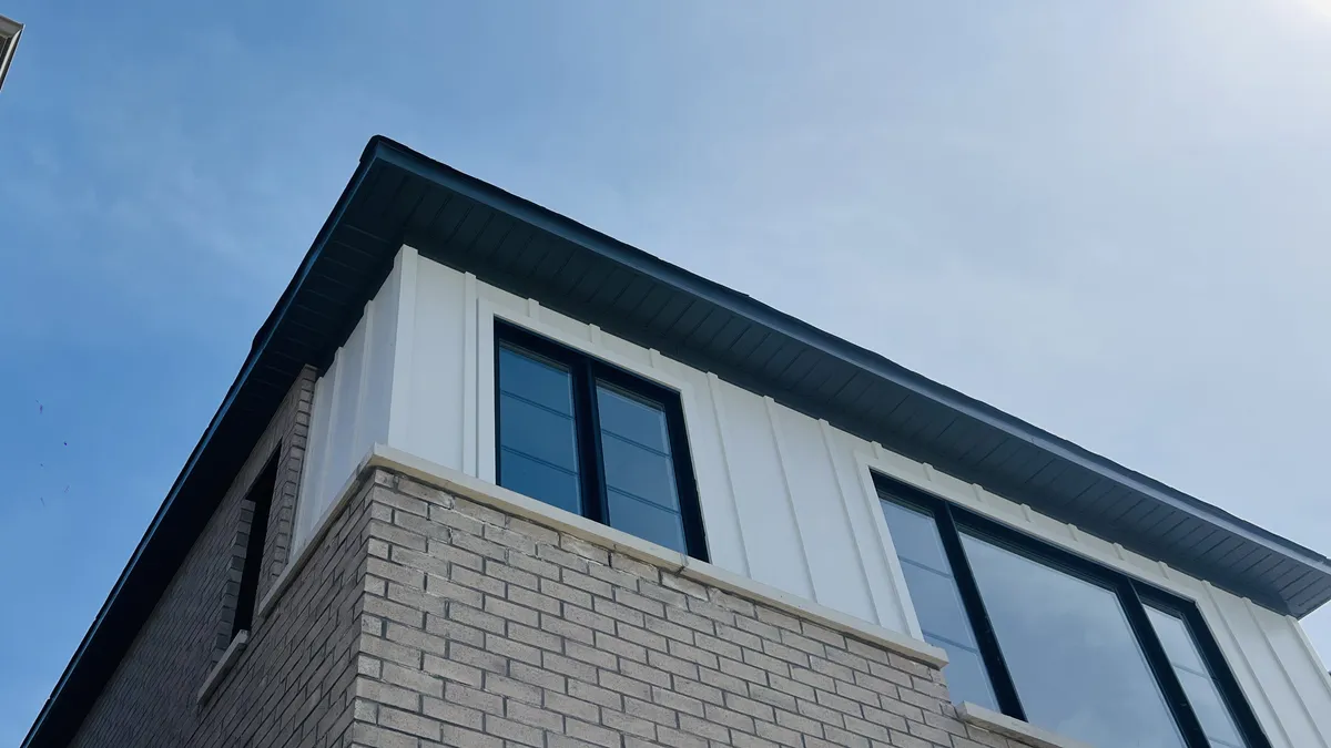 Soffit, fascia, and siding corner detail against the sky