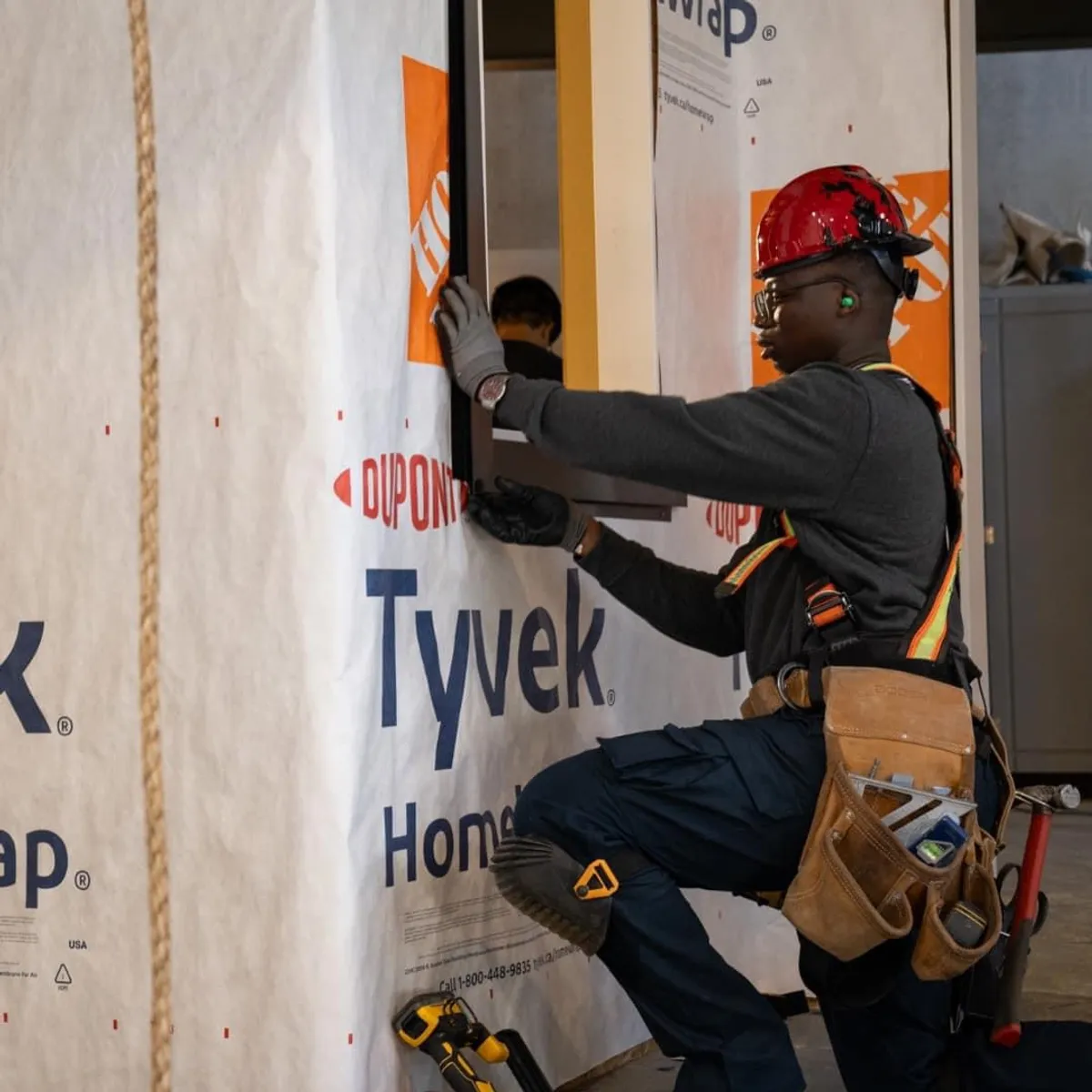 Installer applying house wrap during exterior work